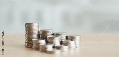 Growth money of profitability of professional investment planning, Business and finance concept. Coins are stacked on each other in different positions on the table with blur background.