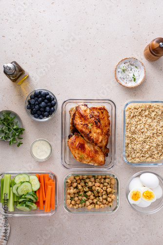 High protein healthy lunch meal prep in containers with chicken, quinoa, herbed chickpeas, vegetables and eggs
