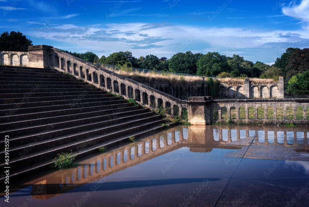 View of the stairs and historical ancient wall from the Victorian style reflected in the water, in the Crystal Palace in London