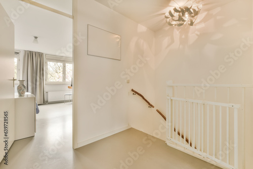 an empty room with white walls and ceiling fan on the wall, there is a staircase leading up to the second floor