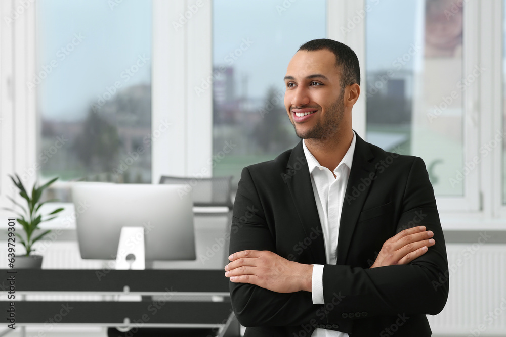 Smiling young businessman in modern office. Space for text Smiling young businessman in modern office. Space for text