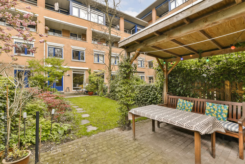 an outside area with a table and bench in the middle part of the yard, surrounded by plants and trees