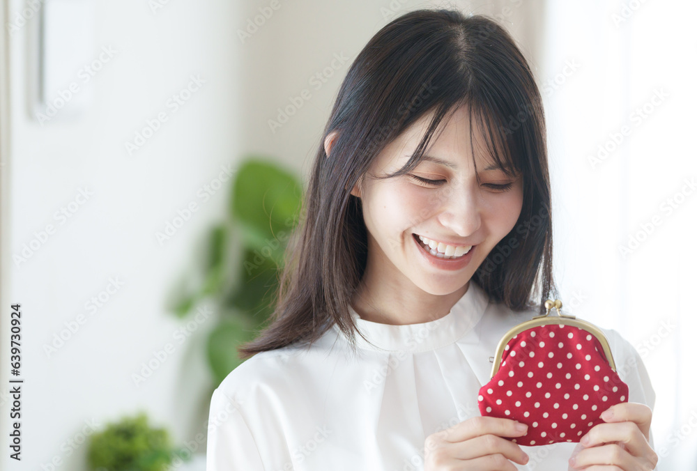がま口の財布を持つ女性（お金・貯金・主婦）