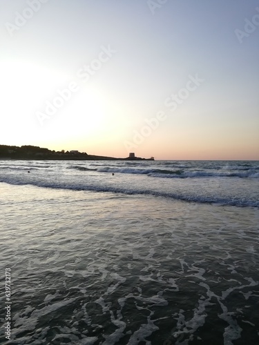 antica torre saracena al tramonto in riva al mare photo