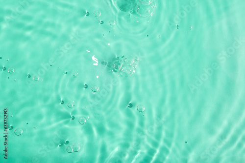 Blurred transparent green colored clear calm water surface texture with splash and bubbles. water waves with shining pattern texture background.Texture of water surface reflections. 