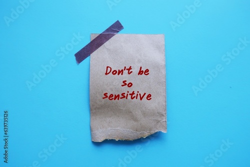 Torn paper stick on blue background with handwriting Don't Be So Sensitive, gaslighting message to accuse or emotional abuse others to question their beliefs or doubt perceptions and become distressed photo