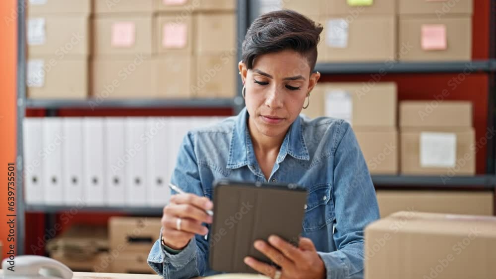 Young beautiful hispanic woman ecommerce business worker writing on touchpad at office Young beautiful hispanic woman ecommerce business worker writing on touchpad at office
