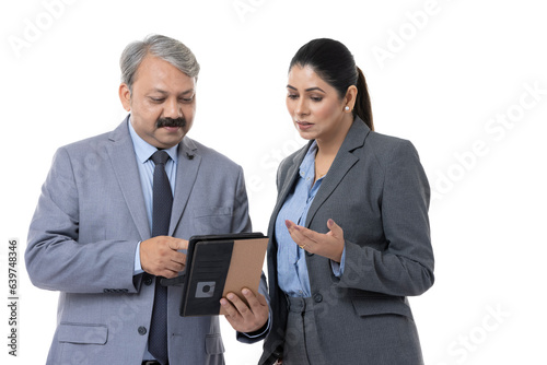 Studio shot of happy mature business colleagues using digital tablet over white background