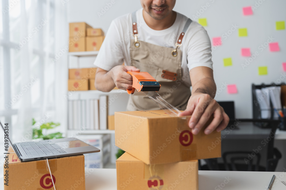 Independent entrepreneurs use scotch tape to attach parcel boxes to prepare goods for the process of packaging, shipping, online sales internet marketing ecommerce concept startup business ideas Independent entrepreneurs use scotch tape to attach parcel boxes to prepare goods for the process of packaging, shipping, online sales internet marketing ecommerce concept startup business ideas