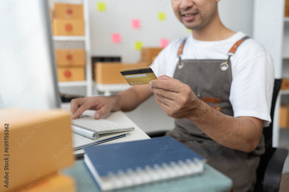 online shopping order concept Man holding credit card and using pc for shopping at home To register a credit card on a computer to create secure electronic payments online. online shopping order concept Man holding credit card and using pc for shopping at home To register a credit card on a computer to create secure electronic payments online.