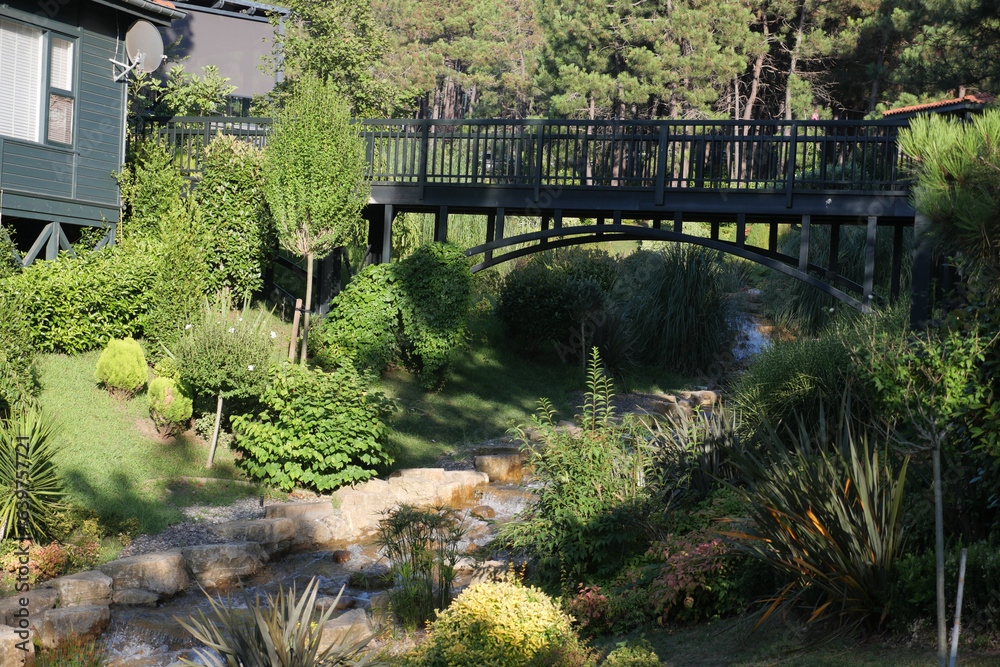 small waterfall with walking bridge at public park small waterfall with walking bridge at public park