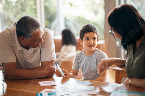 Home school, learning and parents support child with lesson and flash cards for education. Studying, kid and grandfather with teaching, communication and bonding from development and conversation photo