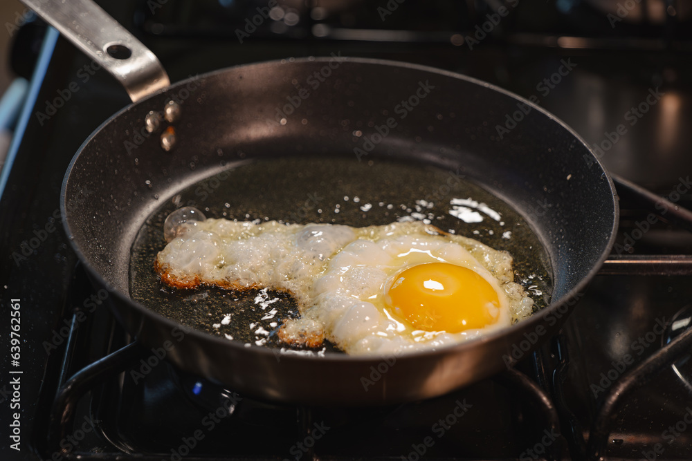 Frying an egg in oil for breakfast on a gas range Frying an egg in oil for breakfast on a gas range