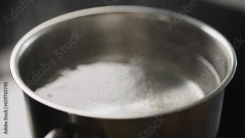 Slow motion boling water in saucepan photo