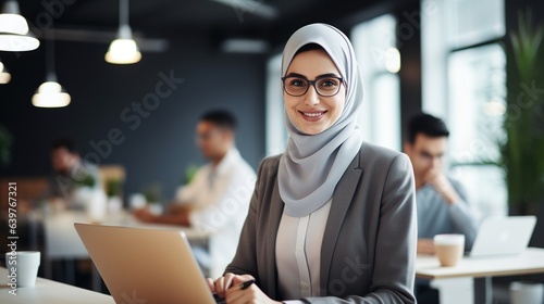 arab saudi person using a laptop computer on her desk office photo