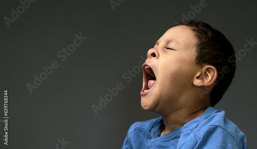 little child yawning with open mouth on dark background with people stock image stock photo