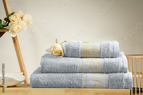 a stack of folded towels on a wooden shelf with a ladder in the background towels on wooden in bath