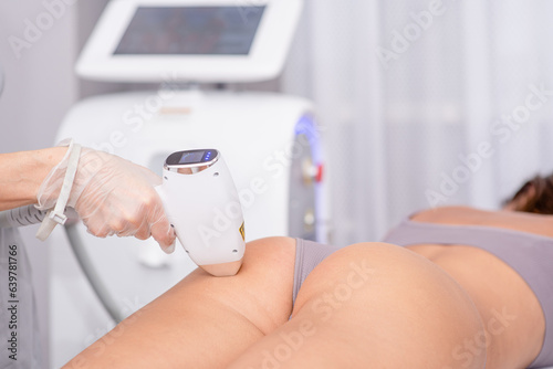 Slika na platnu Professional beautician removes hair on beautiful female buttocks using a laser