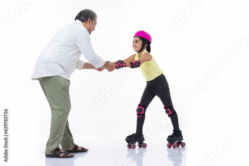 Father helping little daughter skating on roller skating isolated on white background.