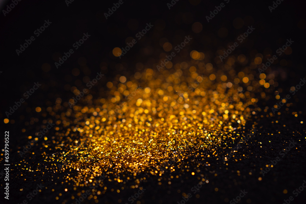 The golden flakes are scattered on the black surface