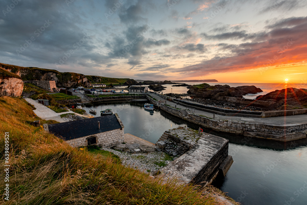 Fototapeta premium Stunning Summer Sunset at the Ballintoy Harbour, Antrim, Northern Ireland 