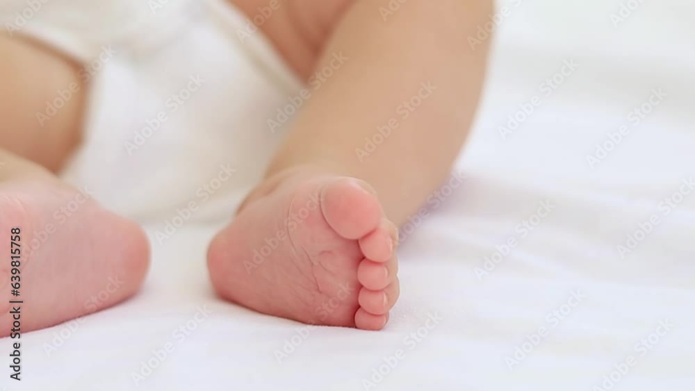 baby's small feet on a white bed, a place for text, a close-up of a little baby's feet baby's small feet on a white bed, a place for text, a close-up of a little baby's feet