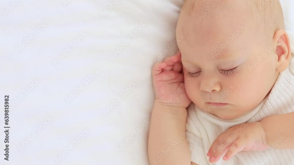 cute little newborn baby sleeps with his hand folded under his cheek, sweet healthy baby sleep in a white crib, a place for text cute little newborn baby sleeps with his hand folded under his cheek, sweet healthy baby sleep in a white crib, a place for text