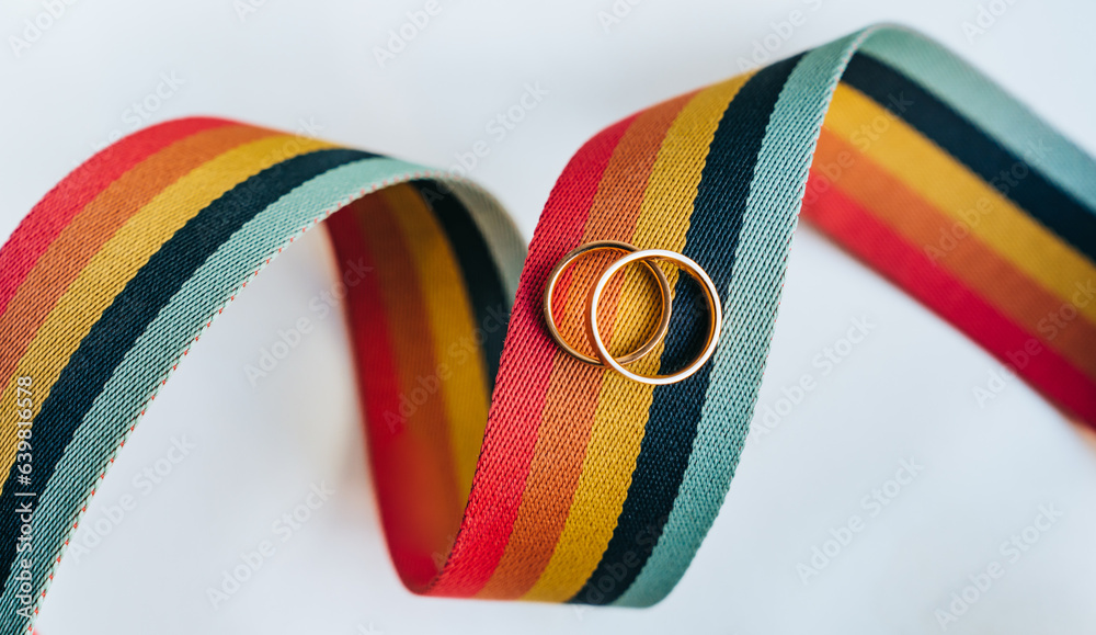 Rainbow coloured ribbon against white background with laying wedding ...