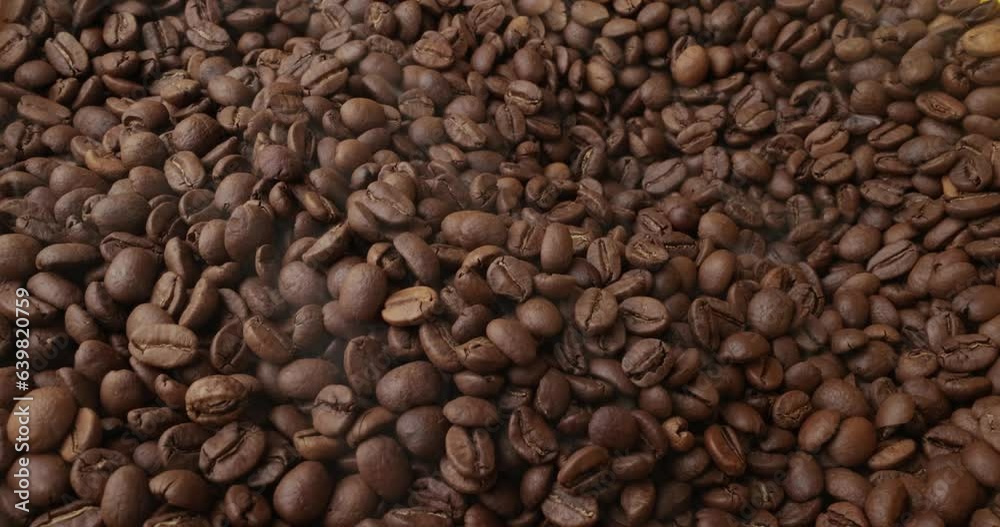 Close up of seeds of coffee. Fragrant coffee beans are roasted smoke comes from coffee beans. Close up of seeds of coffee. Fragrant coffee beans are roasted smoke comes from coffee beans.