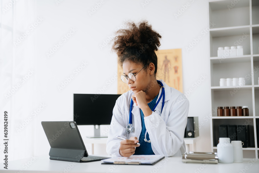 Beautiful physician doctor sit on table in office hospital. Attractive therapist female practitioner pharmacist smile and use tablet and laptop in hospital.after success work from treatment. Beautiful physician doctor sit on table in office hospital. Attractive therapist female practitioner pharmacist smile and use tablet and laptop in hospital.after success work from treatment.