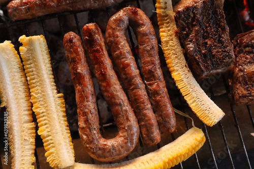 Boerewors sausages on grill with sliced mielies or corn on the cob  photo