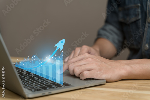 Analysis business growth trends and the company finances. Businessman working touching on laptop with virtual image bar chart, blue arrow pointing to rocket. Future results, performance reports