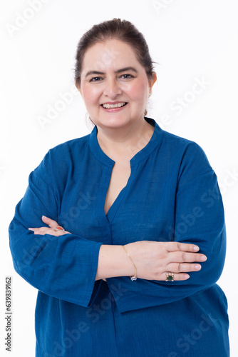 Portrait of confident mature woman wearing formalwear with arms crossed standing against white background