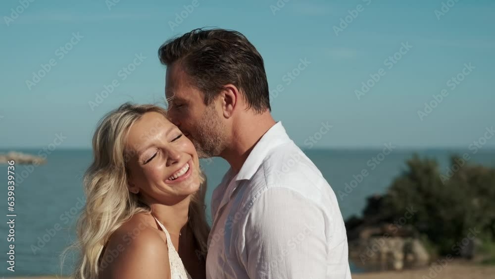 A man and woman in love hugging while standing on the ocean during their honeymoon. A man and woman in love hugging while standing on the ocean during their honeymoon.
