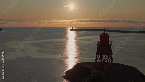 Herd Groyne Lighthouse Panning Drone Shot with lighthouse crossing dawn Sun path 3x Zoom, Tynemouth, Tyne & Wear. photo