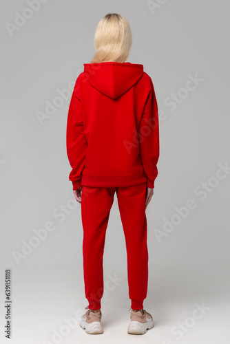 Woman in a red suit of hoodies and sweatpants. Shot from the back. Mock-up.