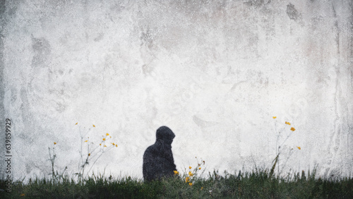A blurred, grunge abstract edit of a strange mysterious hooded figure standing in a field. With a grunge minimal edit.