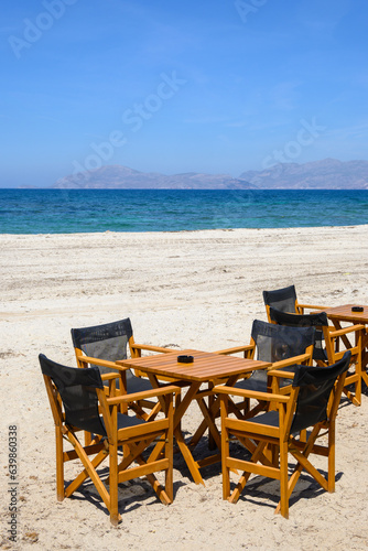 Tables and chairs on the beach in the resort town of Mastichari on the island of Kos. Greece © vivoo