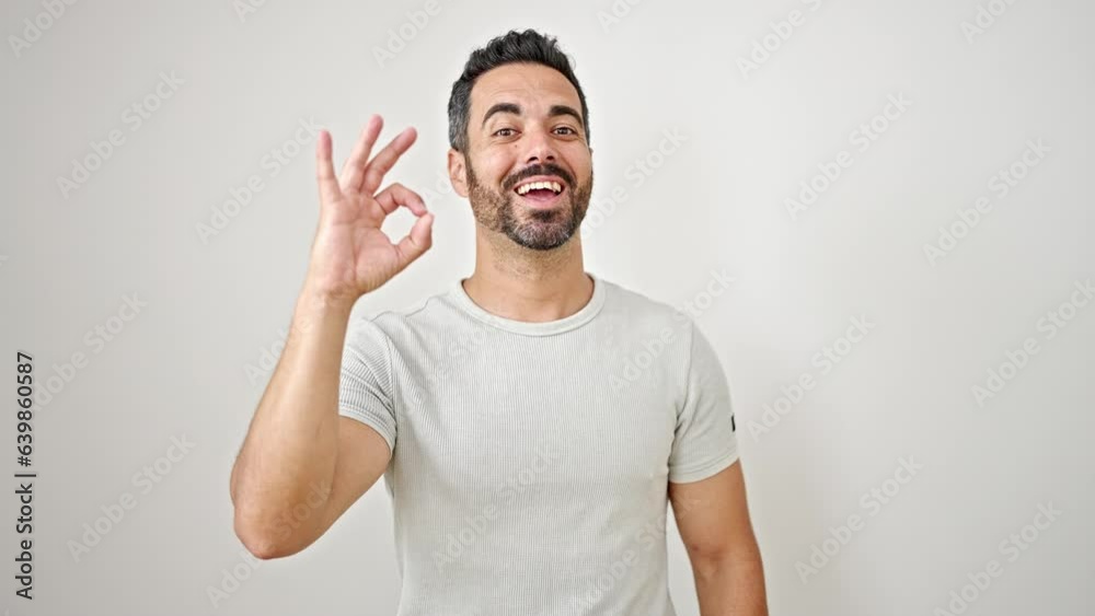 Young hispanic man smiling with doing ok gesture over isolated white background Young hispanic man smiling with doing ok gesture over isolated white background