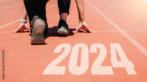 2024 Newyear , Athlete Woman starting on line for start running with number 2023 Start to new year.