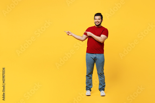 Full body young happy smiling Indian man he wears red t-shirt casual clothes pointing indicate on workspace area copy space mock up isolated on plain yellow orange background studio Lifestyle concept