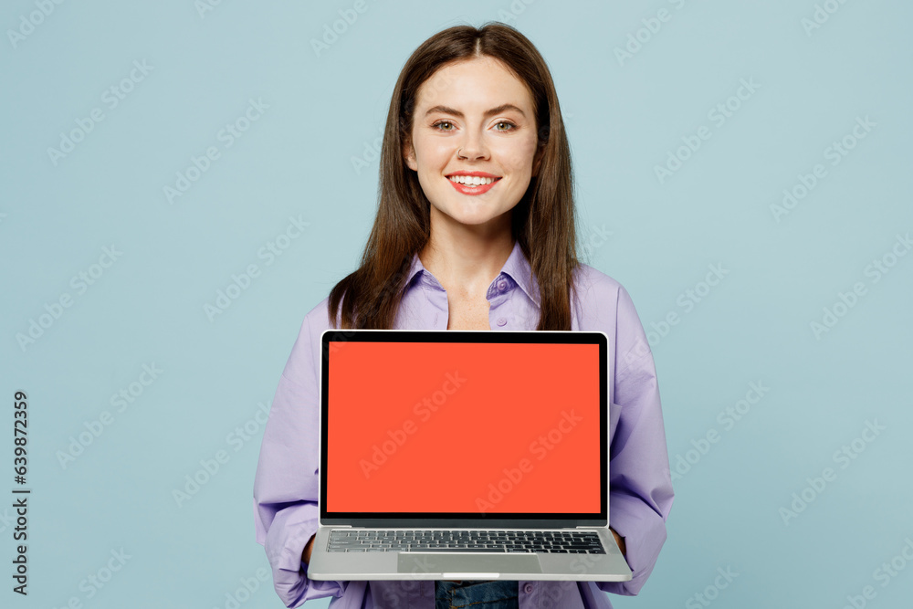 Young IT woman wears purple shirt yellow t-shirt casual clothes hold use work on laptop pc computer with blank screen workspace area isolated on plain pastel light blue background. Lifestyle concept. Young IT woman wears purple shirt yellow t-shirt casual clothes hold use work on laptop pc computer with blank screen workspace area isolated on plain pastel light blue background. Lifestyle concept.