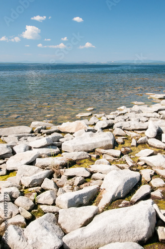 Uvildy lake in summer with stones on its shore in the foreground, South Urals, Russia photo