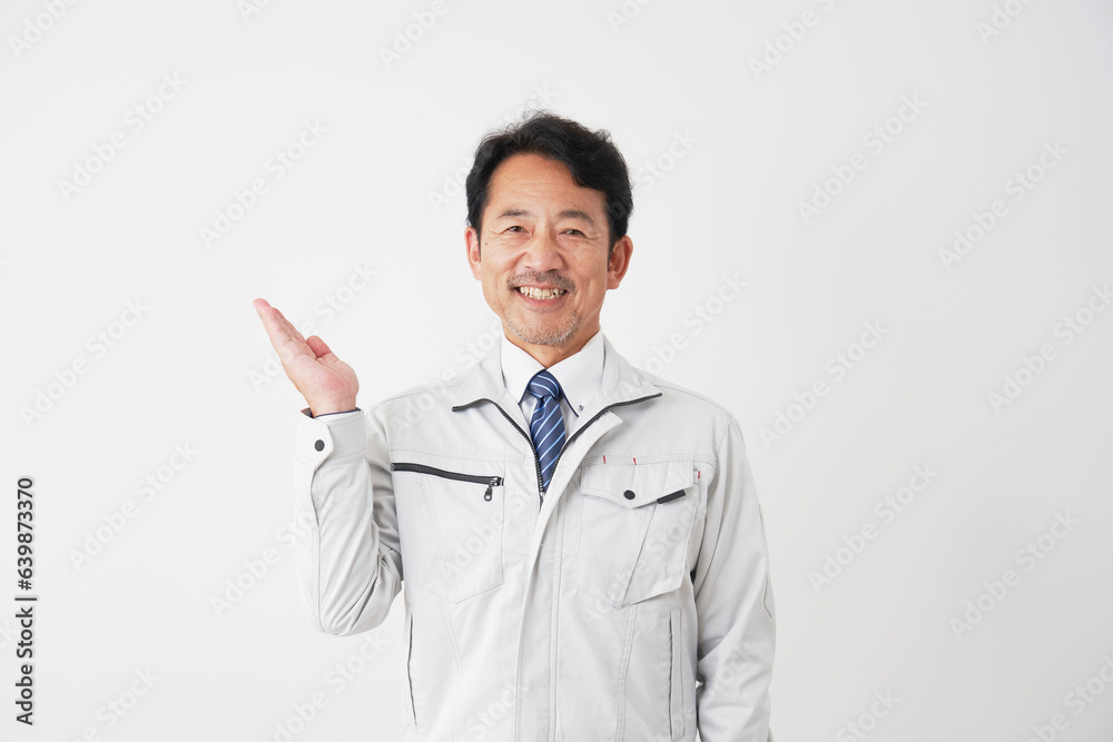 左側を手のひらで指すミドルエイジの作業員　白背景