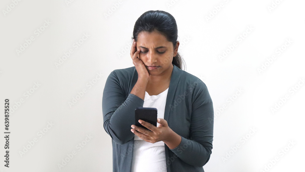 Indian young women checking her mobile to call her dentist for tooth pain appointment Indian young women checking her mobile to call her dentist for tooth pain appointment