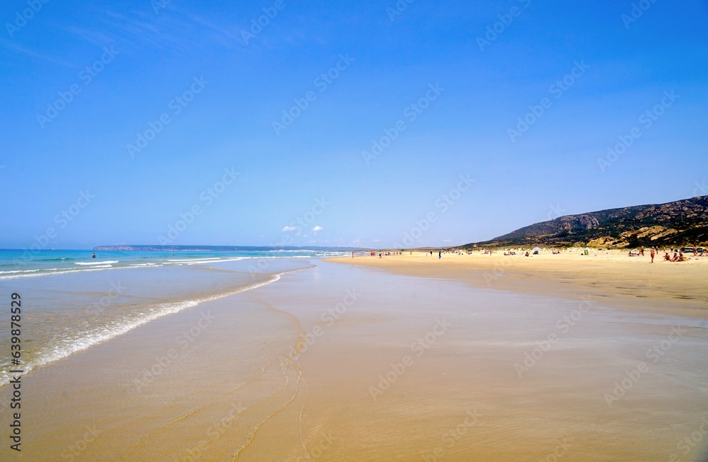 beach at the Atlantic Ocean in Zahara de los Atunes with a view towards Barbate at the horizon on a summer day, Playa del Cabo de la Plata, Costa de la Luz, Andalusia, Cadiz, Province, Spain