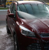 washing a car outside, a red car at a car wash, outdoor