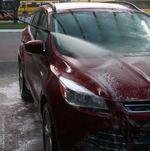 washing a car outside  a red car at a car wash  outdoor