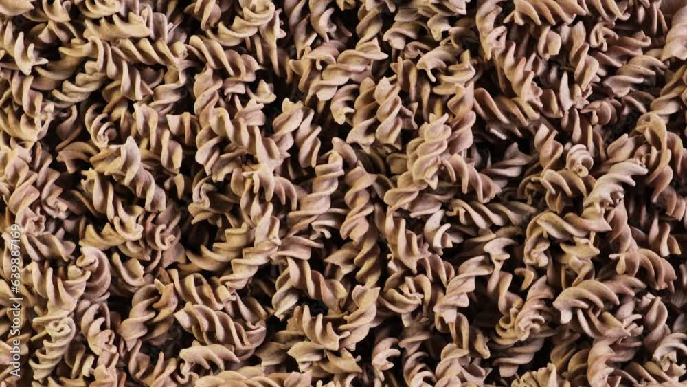 Flaxseed gluten free pasta, close-up. Fusilli made from flax and corn flour. Pasta di Lino. Low glycemic index food. Video 4K, Rotating. Flaxseed gluten free pasta, close-up. Fusilli made from flax and corn flour. Pasta di Lino. Low glycemic index food. Video 4K, Rotating.