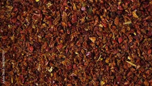 Dried crushed pepper Gochugaru, close-up. Medium-ground red dry pepper uses in Korean cuisine for kimchi, gochujang and other savory dishes. Popular spicy condiments. 4K video, Rotating. photo